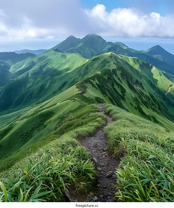 Mountain Ridge Hiking Trail with Green Grass and Clouds