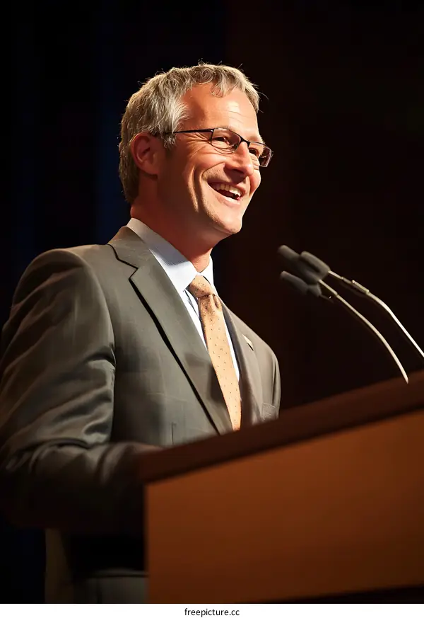Smiling Man in Suit Speaking at a Podium