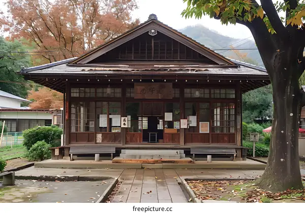 A small wooden building with a tiled roof and a sign that says Nishikyo Ward Office.