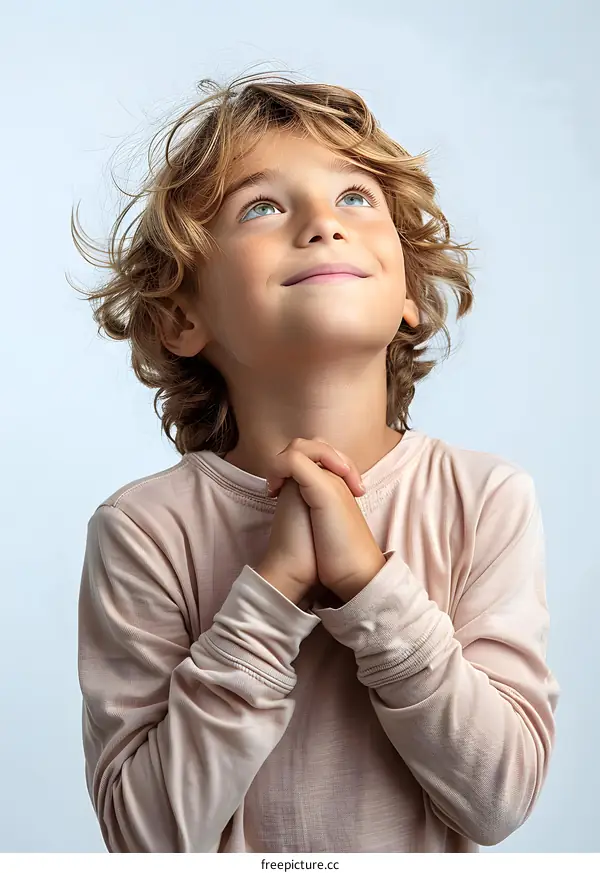 Portrait of a young boy with blond hair and blue eyes looking up