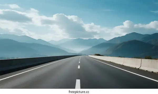 A Long Highway Leading Through Mountainous Scenery Under a Clear Sky