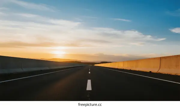Sunset view of an empty highway under a clear blue sky