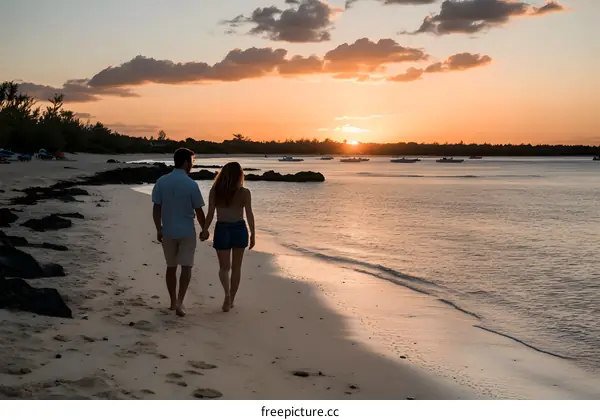 Couple Walking on Beach at Sunset with Boats in the Distance