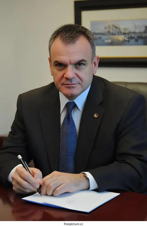 Man in Suit Writing on a Paper