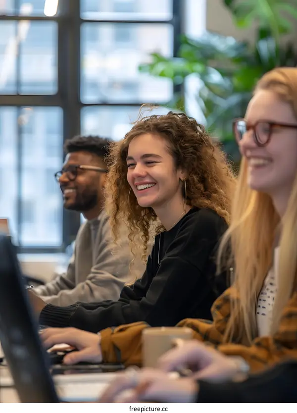 Smiling Coworkers Working on Computers in a Modern Office