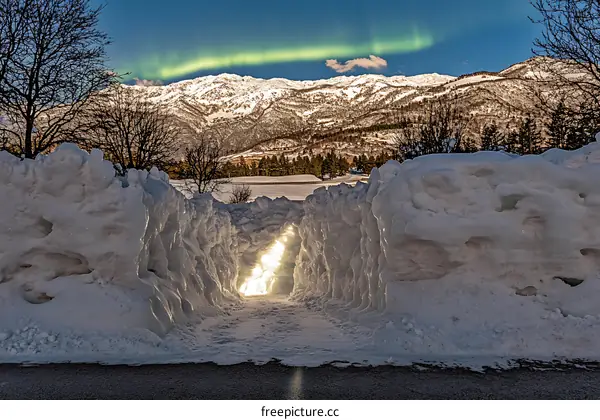 Snowy Pathway Leading to Mountain View with Aurora Borealis
