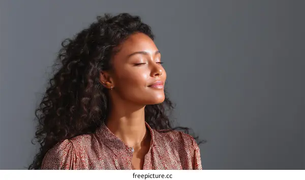 A Young Woman with Curly Hair Closing Eyes and Breathing Deeply