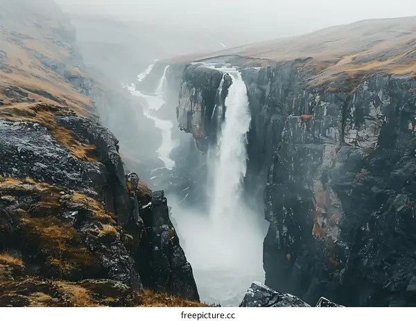 Waterfall Flowing Through Mountain Canyon