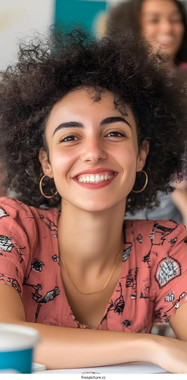 Smiling Woman With Curly Hair In Pink Shirt