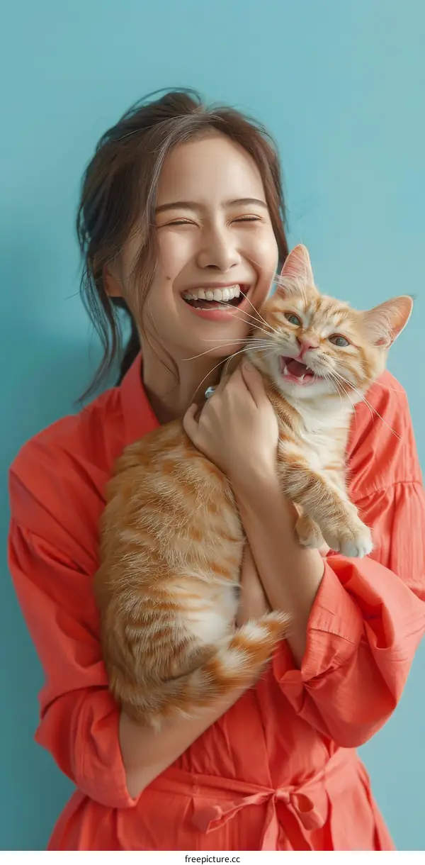 Laughing woman holding an orange cat