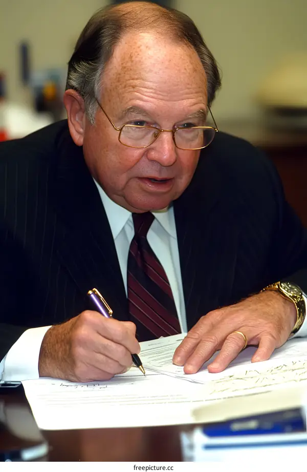 Senior Businessman Signing a Document in Office