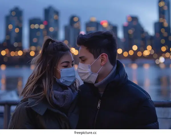 A masked couple gazes into each other's eyes in front of a blurred city skyline at dusk