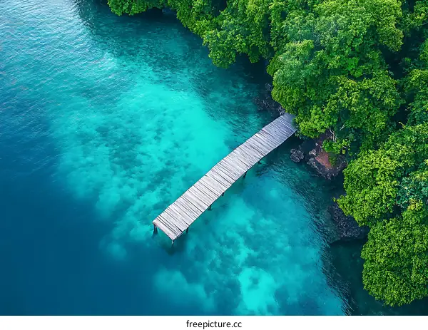 Aerial View of Wooden Pier Extending into Clear Blue Water