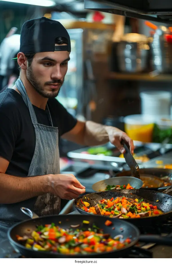 Young male chef cooking in a commercial kitchen