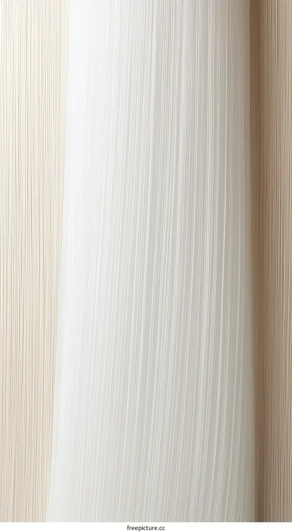 Close-up of a white curtain with beige and brown wall in the background