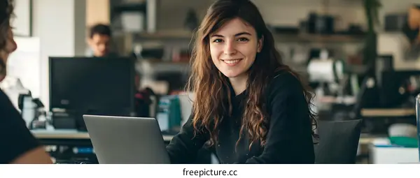 Smiling Woman Working On Laptop In Modern Office