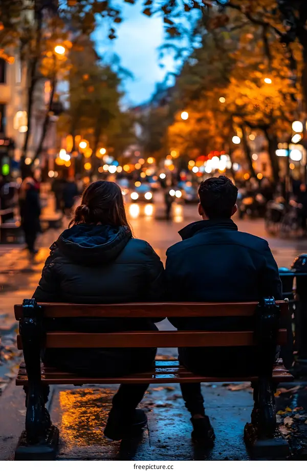 Couple Sitting on Bench in City at Night