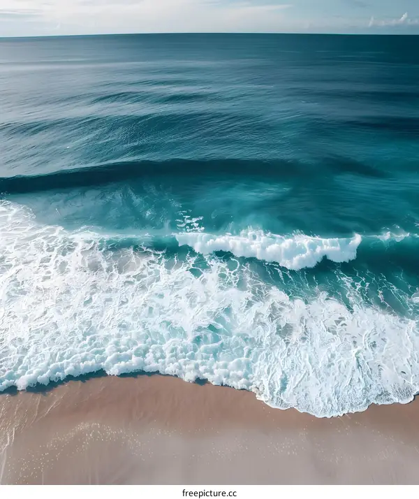 Aerial View of Ocean Waves Crashing on Sandy Beach