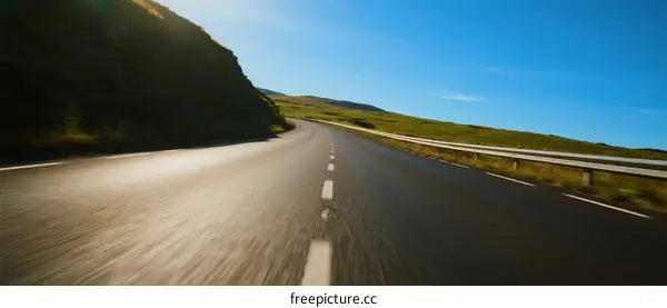 Smooth highway with clear sky and green landscape on both sides
