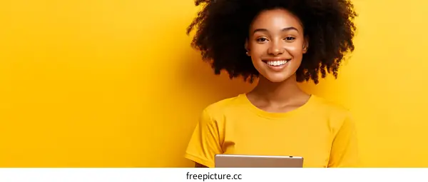 Smiling Woman Holding Tablet On Yellow Background