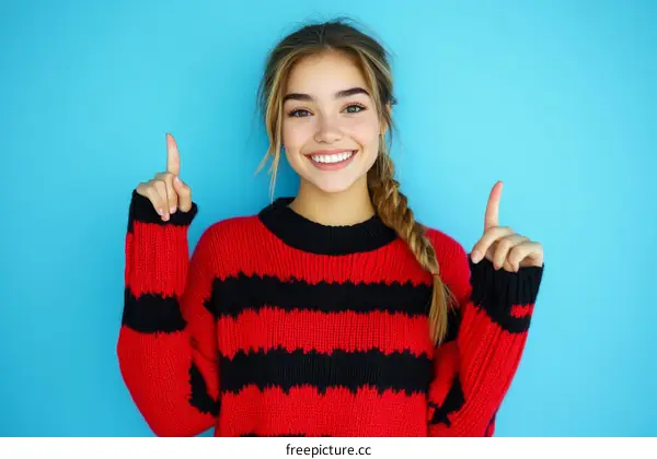 Smiling Caucasian Woman Pointing in a Red and Black Sweater