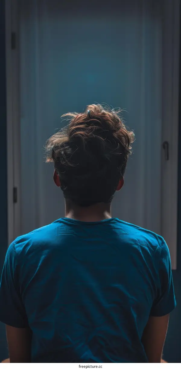 Man in blue shirt standing in front of door