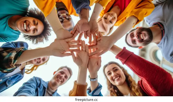 A group of diverse young people holding hands in a circle
