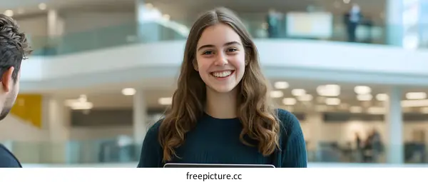 Smiling Young Woman with Blonde Hair in Modern Office