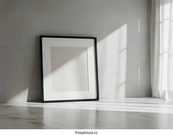 Empty Picture Frame Leaning Against Gray Wall with Sunlight