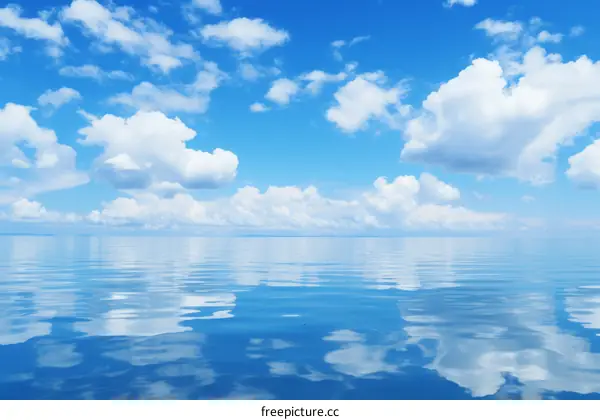 Blue sky and white clouds reflecting on the calm water surface
