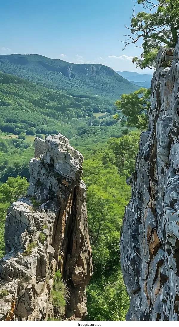 Two rocky peaks with a valley and mountains in the background