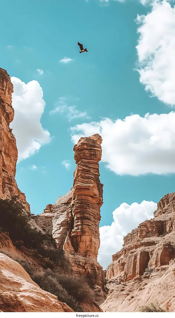 A Tall Rock Formation Stands Tall Against A Bright Blue Sky