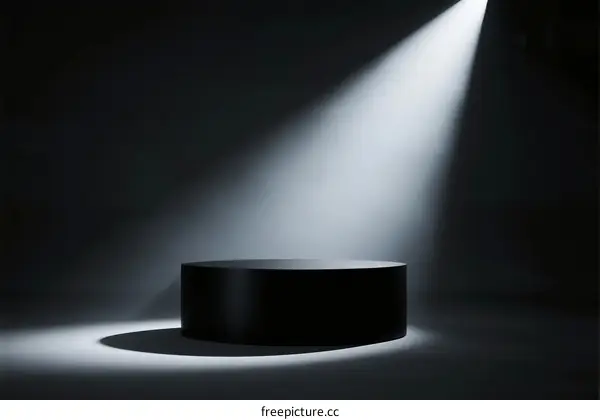 A single black pedestal illuminated by a bright spotlight in a dark background