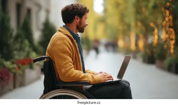 Caucasian Man in Wheelchair Using Laptop Outdoors