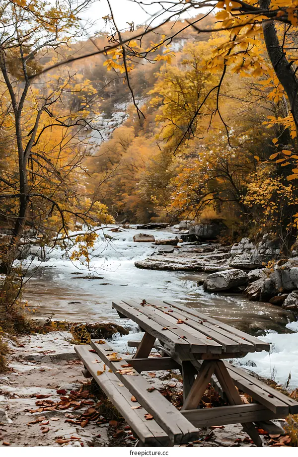 Wooden Picnic Table By A River In The Fall