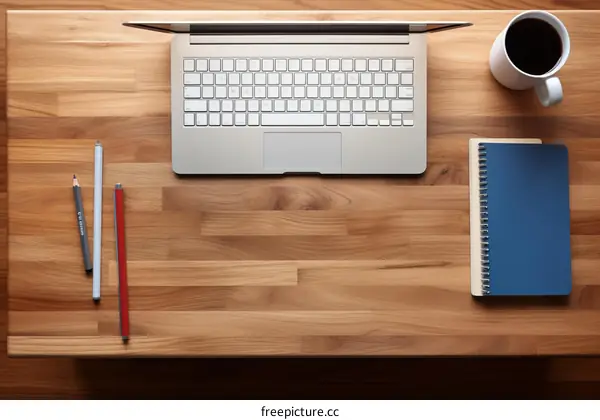 Laptop, Notebook, Coffee, and Pencils on a Wooden Desk