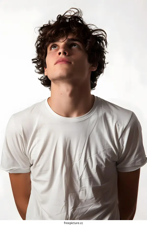 portrait of a young man with curly hair looking up