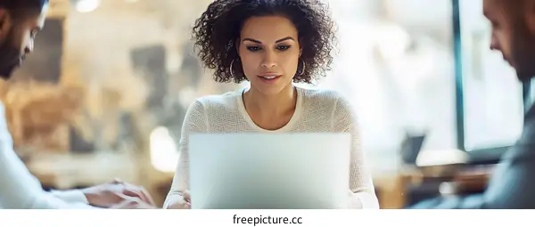 Focused Young Woman Working On Laptop Computer in Office