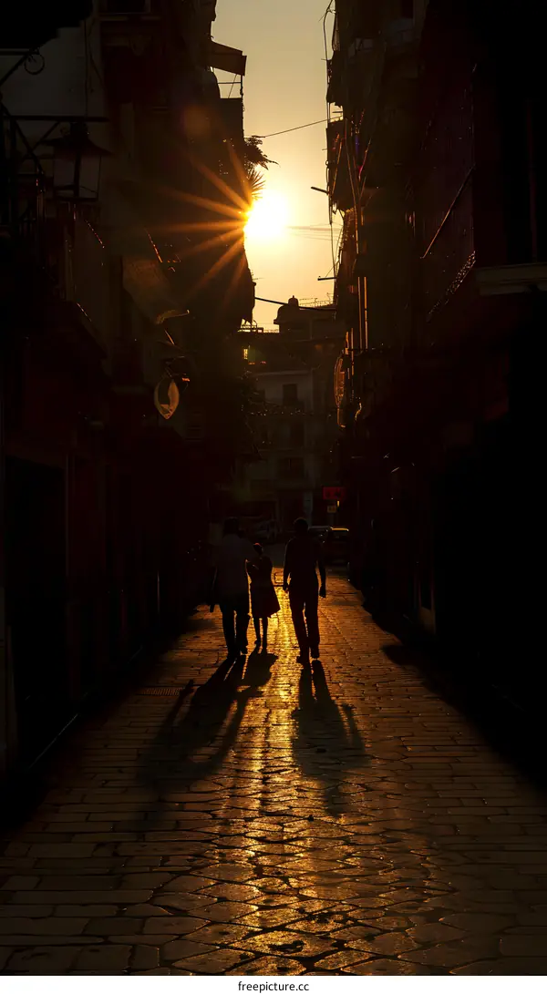 Silhouettes of People Walking in a Narrow Alleyway during Sunset
