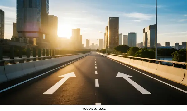 Sunlit urban highway with modern skyscrapers in the background