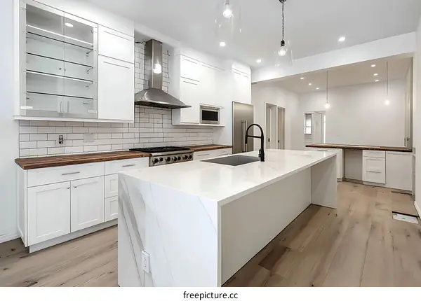 Modern White Kitchen with Island and Hardwood Flooring