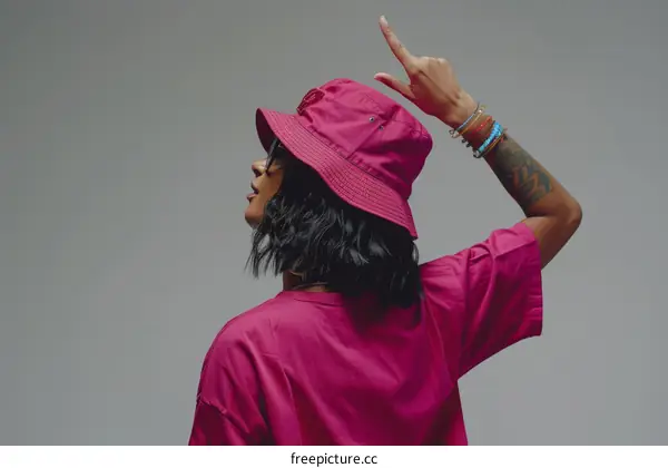 A young woman wearing a pink bucket hat and sunglasses