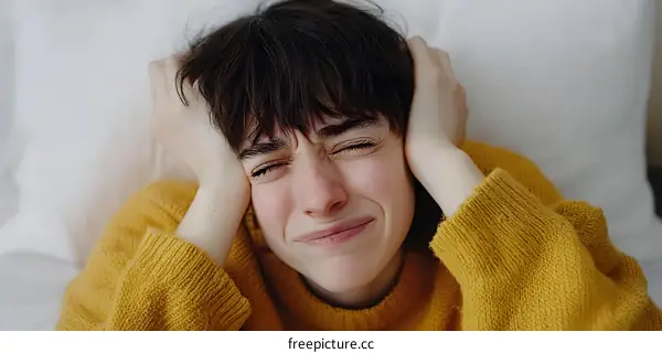 Woman in Yellow Sweater with Hands Covering Her Ears