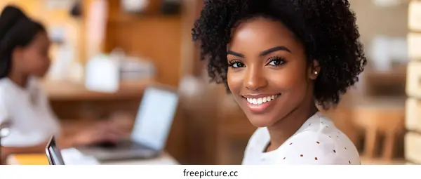 Smiling Black Woman Using Laptop In Cafe