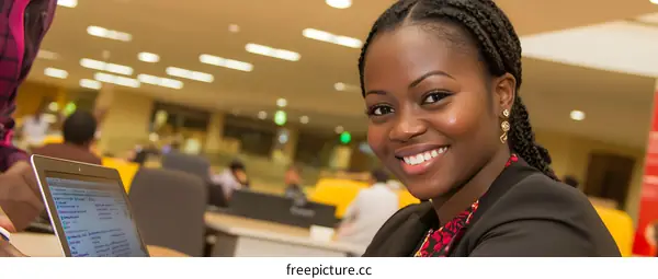 Smiling African Woman Working on Laptop in Office