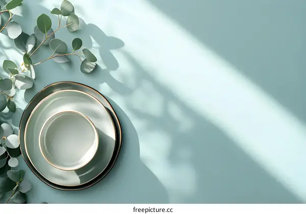 Empty Plates and Green Leaves on a Light Blue Background