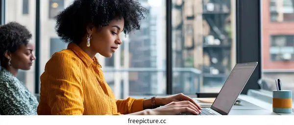 African American Woman Working on Laptop in Office Setting
