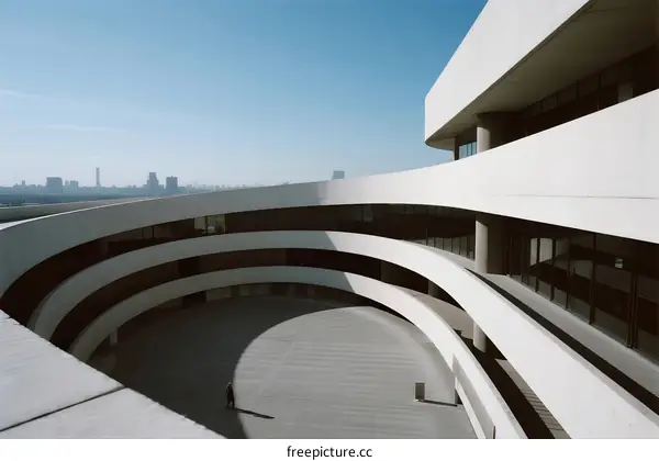 Modern Curved Concrete Building with Urban Skyline View