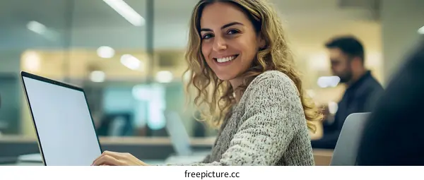Smiling Woman Working on Laptop in Office