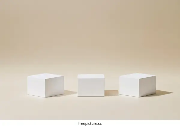 Three White Cubic Display Stands Against a Beige Background